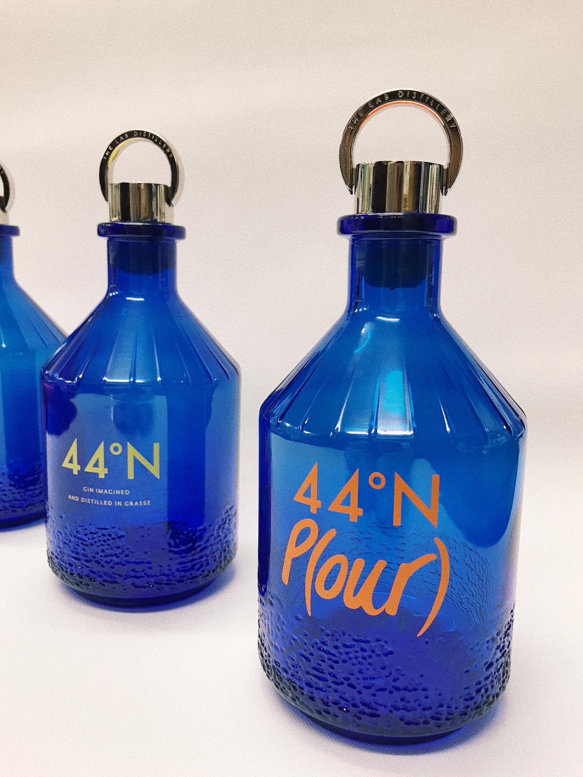 Orange and Yellow Contour Cut Logo Decals onto Blue Glass Bottles